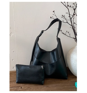 Close-up of black retro hobo tote bag set showing leather texture and matching small pouch