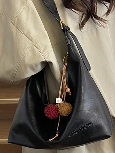 Fashionable black large capacity tote bag with ethnic style pendant and wide strap