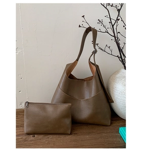 Macro detail of retro deep brown leather texture and two-piece tote bag set with pouch