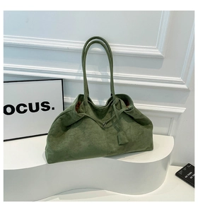 Vue détaillée du sac cabas en daim vert foncé montrant la texture douce et les coutures