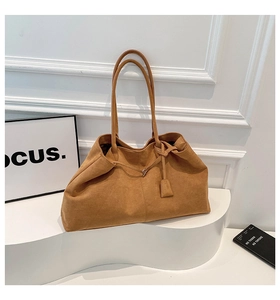 Détail d'un grand sac cabas en daim marron avec cordons et texture souple minimaliste