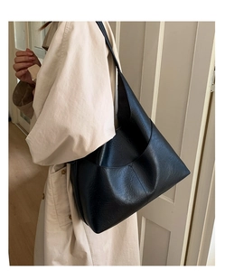 Detail of large black hobo shoulder bag with textured faux leather and wide strap