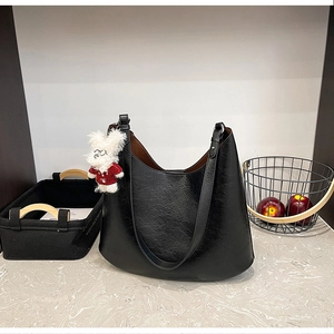 Détail du grand sac hobo noir en cuir ciré avec un pendentif lapin blanc mignon