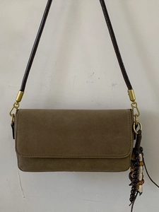 Minimalist tan suede baguette shoulder bag with golden hardware and wooden bead charm