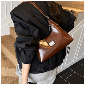 Detailweergave van vintage bruine hobo tas met zilveren gesp en smalle schouderriem