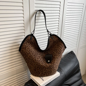 Détail d'un cabas en suédine à imprimé léopard avec bordures en cuir noir et texture