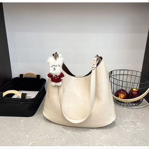 Vue détaillée d'un sac hobo crème avec un porte-clés en peluche d'ours mignon et doux