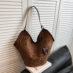 Vue détaillée du grand sac cabas léopard avec anses en cuir marron et pendentif décoratif