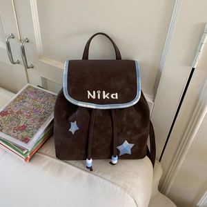 Detail of vintage brown suede mini backpack with checkered star patch and NiKa embroidery