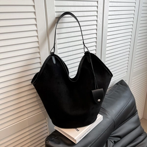 Détail de la texture d'un sac hobo en daim noir minimaliste avec bandoulière et pochette