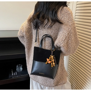 Detail of two-tone suede bucket bag with HAMIROO logo and wooden gourd charm