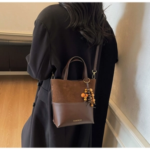 Detail of vintage brown leather and suede handbag showing exquisite stitching and texture