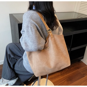 Vue détaillée du sac cabas en daim marron clair avec des accents métalliques dorés