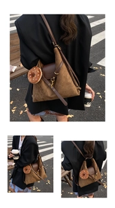 Detail of brown suede multi-way backpack with leather flap and donut plush charm