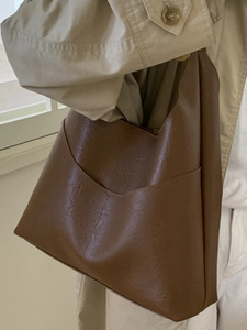 Minimalist vintage dark brown tote bag in textured leather with V-shaped front pocket