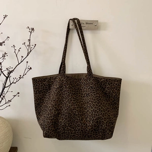 Detail of vintage leopard print suede tote bag with wide shoulder strap on hook