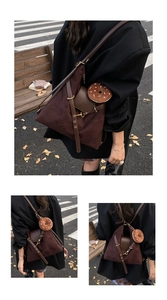 Detail of suede crossbody bag with gold hardware and donut charm on city street