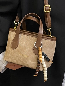 Retro bucket bag in beige fabric and brown leather with a wooden bead charm