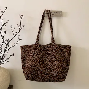 Detailed close-up of leopard print pattern on high-capacity suede tote bag texture