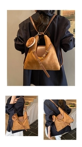 Detail view of brown suede tote bag featuring leather flap and cute donut plush charm