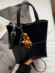 Minimalist black patchwork tote bag with suede finish and decorative beads