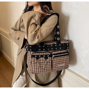 Detail of checkered punk tote bag featuring silver rivet pockets and metal chain decoration