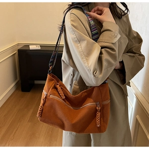 Detail of caramel corduroy tote bag with ethnic style colorful woven shoulder strap