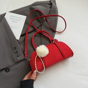 Detail of red suede bowling bag with white faux fur pompom and pearl chain strap decoration
