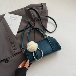 Detailed view of suede texture on navy blue bowling bag with faux fur pom pom and pearl ring