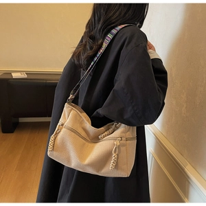 Detail of beige corduroy tote bag with vintage colorful woven shoulder strap for women