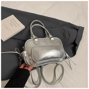 Detail view of silver Boston bag with metallic finish, gold zippers, and double top handles