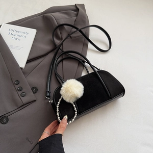 Detail of suede bowling bag with contrast panels, fluffy pom-pom and pearl charm