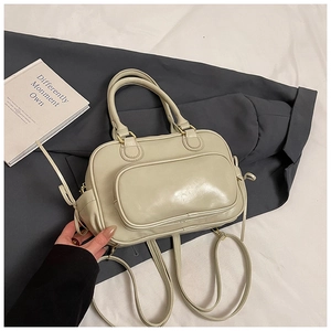Close-up of cream Boston bag with fine leather texture and golden metal zipper details