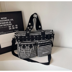 Detail of checkered punk tote bag with metal rivets, chains, and multiple functional pockets