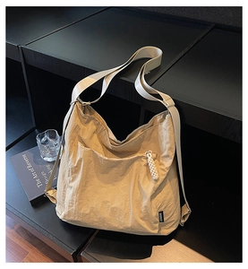 Détail du sac fourre-tout beige avec tirette de fermeture en corde et large bandoulière