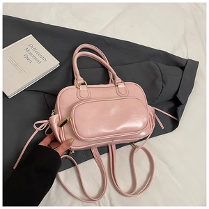 Detail of light pink Boston bag with golden hardware and front zipper pocket close-up