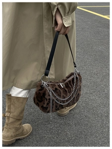 Detail der hobo-Tasche mit Leopardenmuster und Kettenriemen kombiniert mit Trenchcoat
