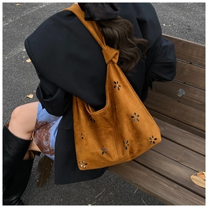 Détails du motif floral découpé au laser sur le sac fourre-tout en daim caramel