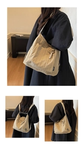 Détails du sac multifonctionnel en toile kaki montrant la texture et les styles de port