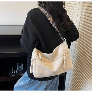 Detail of off-white corduroy tote bag featuring a colorful bohemian wide shoulder strap