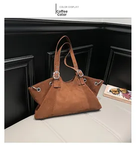 Detail of coffee brown suede tote bag featuring metallic buckles and retro workwear style