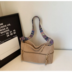 Detail of khaki corduroy tote bag with ethnic embroidery strap and zip pocket texture