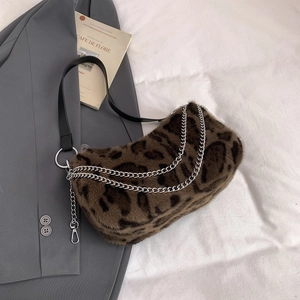 Detailansicht der Leoparden-Kunstfelltextur mit silberner Metallkette und Lederriemen
