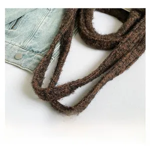 Detail shot of the comfortable knit handle and thick wool texture of the brown tote bag