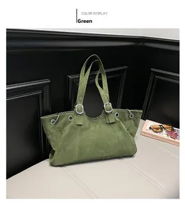 Detail view of large dark green suede tote bag showing metallic silver eyelet accents