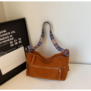 Detail of caramel corduroy tote bag showing woven ethnic strap and zipper pocket texture