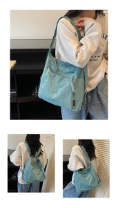 Détail du sac bandoulière en nylon bleu avec tissu résistant à l'eau et poche latérale zippée