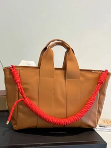 Brown large capacity tote bag with unique red rope shoulder straps for commute