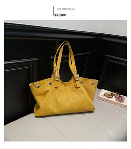 Detail view of yellow faux suede tote bag with silver eyelets and adjustable strap