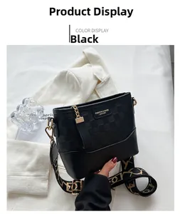 Detail of black bucket bag with woven texture, golden chain, and fashion strap